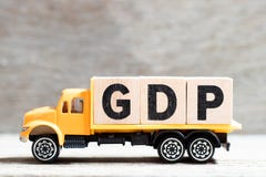 Truck hold block in word GDP Abbreviation of good distribution practice or gross domestic product on wood background