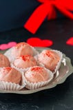 Truffes blanches de chocolat et de fraise sur le backgroun en pierre noir Images stock Truffes blanches de chocolat et de fraise sur le backgroun en pierre noir Images stock