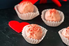 Truffes blanches de chocolat et de fraise sur le backgroun en pierre noir Photographie stock libre de droits Truffes blanches de chocolat et de fraise sur le backgroun en pierre noir Photographie stock libre de droits