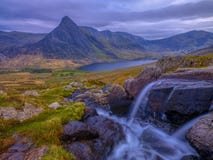 Tryfan in primavera con il Afon Lloer nel flusso sopra le cascate, Galles fotografie stock Tryfan in primavera con il Afon Lloer nel flusso sopra le cascate, Galles fotografie stock