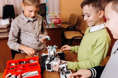 Trzy szczęśliwej chłopiec robią robotom w szkole robotyka obrazy royalty free Trzy szczęśliwej chłopiec robią robotom w szkole robotyka obrazy royalty free