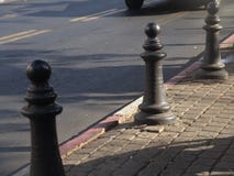 Três cargos do metal em uma opinião urbana pavimentada do passeio na luz do dia fotografia de stock royalty free Três cargos do metal em uma opinião urbana pavimentada do passeio na luz do dia fotografia de stock royalty free