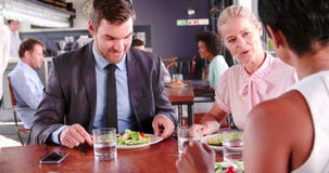 Três empresários que têm o almoço de funcionamento no restaurante video estoque Três empresários que têm o almoço de funcionamento no restaurante video estoque