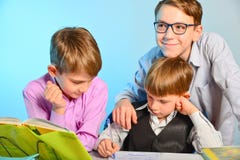 Três estudantes fazem lições da escola junto, resolvem tarefas dos trabalhos de casa fotografia de stock royalty free Três estudantes fazem lições da escola junto, resolvem tarefas dos trabalhos de casa fotografia de stock royalty free