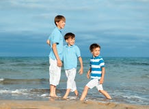 Três irmãos são jogo na praia Imagens de Stock Royalty Free Três irmãos são jogo na praia Imagens de Stock Royalty Free