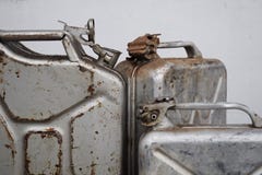 Três latas cinzentas com gasolina ou diesel, tambor do metal imagem de stock Três latas cinzentas com gasolina ou diesel, tambor do metal imagem de stock