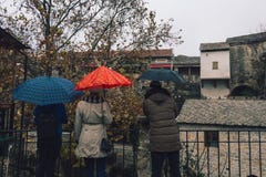 Três pessoas com guarda-chuvas Rua em Mostar imagens de stock Três pessoas com guarda-chuvas Rua em Mostar imagens de stock