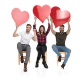 Três povos ocasionais com mãos no ar que comemoram o amor imagem de stock royalty free Três povos ocasionais com mãos no ar que comemoram o amor imagem de stock royalty free