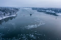 Tug boat on a calm sea with ice chunks in winter