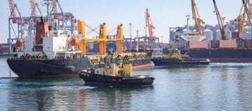 Tugboat pomaga ładunku statek manewrował w port Odessa, Ukraina zdjęcia stock Tugboat pomaga ładunku statek manewrował w port Odessa, Ukraina zdjęcia stock