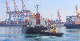 Tugboat στο τόξο του φοÏÏ„Î·Î³Î¿Ï Ï€Î»Î¿Î¯Î¿Ï…, που βοηθά το σκάφος για να ελιχτεί στ στοκ εικόνα με δικαίωμα ελεύθερης χρήσης Tugboat στο τόξο του φοÏÏ„Î·Î³Î¿Ï Ï€Î»Î¿Î¯Î¿Ï…, που βοηθά το σκάφος για να ελιχτεί στ στοκ εικόνα με δικαίωμα ελεύθερης χρήσης