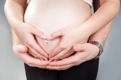 Tummy беременной женщины с сердцем сделал 2 пар рук стоковые изображения rf Tummy беременной женщины с сердцем сделал 2 пар рук стоковые изображения rf