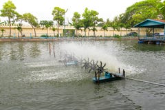 A turbina em uma lagoa que trabalha o oxigenação mecânico na água imagem de stock A turbina em uma lagoa que trabalha o oxigenação mecânico na água imagem de stock