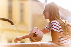 Turist för ung kvinna som förnyar vid den offentliga springbrunnen på en varm sommardag royaltyfri bild Turist för ung kvinna som förnyar vid den offentliga springbrunnen på en varm sommardag royaltyfri bild