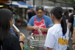 Turist- ätapopcicle på den Chatuchak marknaden i Bangkok royaltyfria foton Turist- ätapopcicle på den Chatuchak marknaden i Bangkok royaltyfria foton