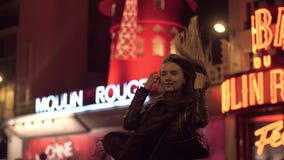 Turista da mulher que levanta para fazer o melhor tiro perto do vermelho de Moulin na noite Paris filme Turista da mulher que levanta para fazer o melhor tiro perto do vermelho de Moulin na noite Paris filme