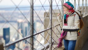 Turista feliz de la mujer joven en la plataforma de observación del Empire State Building en New York City Viajero femenino que d foto de archivo libre de regalías Turista feliz de la mujer joven en la plataforma de observación del Empire State Building en New York City Viajero femenino que d foto de archivo libre de regalías