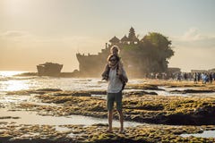 Turistas del padre y del hijo en el fondo de la porción de Tanah - templo imagenes de archivo Turistas del padre y del hijo en el fondo de la porción de Tanah - templo imagenes de archivo