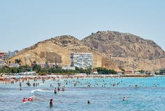 Turistas que tomam sol em uma praia de Postiguet da cidade de Alicante spain Foto de Stock Turistas que tomam sol em uma praia de Postiguet da cidade de Alicante spain Foto de Stock
