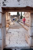 Turister går och kontrollerar fördärvar av den vita synagogan i Capernaum royaltyfri fotografi Turister går och kontrollerar fördärvar av den vita synagogan i Capernaum royaltyfri fotografi