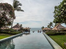 Turister i oändlighetspöl med havbakgrund i Bali arkivfoton Turister i oändlighetspöl med havbakgrund i Bali arkivfoton
