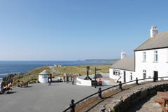 Turister som går i byn av länders slut suddighet vatten f?r uk f?r slutaren f?r cornwall liggander?relse l?ngsamt royaltyfria foton Turister som går i byn av länders slut suddighet vatten f?r uk f?r slutaren f?r cornwall liggander?relse l?ngsamt royaltyfria foton