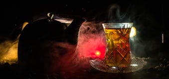 TurkAzerbajdzjan te i traditionell glasse och kruka på svart bakgrund med ljus och rök Armudu traditionell kopp arkivbilder TurkAzerbajdzjan te i traditionell glasse och kruka på svart bakgrund med ljus och rök Armudu traditionell kopp arkivbilder
