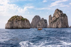 Turyści na łódkowatej wycieczce sławny Faraglioni kołysają przy Capri coas fotografia royalty free Turyści na łódkowatej wycieczce sławny Faraglioni kołysają przy Capri coas fotografia royalty free