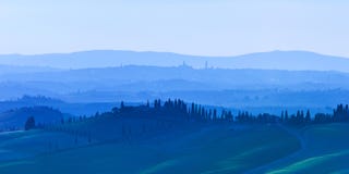 Siena Rolling Hills på blåttsolnedgång. Lantligt landskap med cypresstrees. Tuscany Italien royaltyfri bild Siena Rolling Hills på blåttsolnedgång. Lantligt landskap med cypresstrees. Tuscany Italien royaltyfri bild