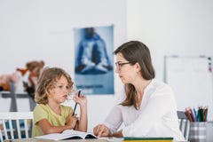 Tutor having a lesson with an absentminded child with concentration issues royalty free stock photos Tutor having a lesson with an absentminded child with concentration issues royalty free stock photos