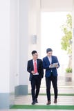 Tv? vietnamesiska manliga coworkers som talar och ler arkivfoto Tv? vietnamesiska manliga coworkers som talar och ler arkivfoto