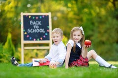 Två förtjusande lilla skolbarn som känner sig upphetsade om att gå tillbaka till skolan arkivfoton Två förtjusande lilla skolbarn som känner sig upphetsade om att gå tillbaka till skolan arkivfoton