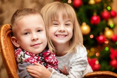 Två småbarn i bakgrunden av julgranen Arkivfoto Två småbarn i bakgrunden av julgranen Arkivfoto