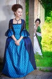 Två unga härliga kvinnor i långa medeltida klänningar Royaltyfri Fotografi Två unga härliga kvinnor i långa medeltida klänningar Royaltyfri Fotografi