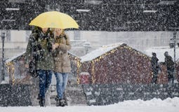 Två unga kvinnor som går under paraplyet i tungt snöfall i stadsgata arkivbild Två unga kvinnor som går under paraplyet i tungt snöfall i stadsgata arkivbild