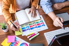 Twee collega creatieve grafische ontwerper die aan kleurenselectie en kleurenmonsters werken, die op grafiektablet op het werk tr stock foto Twee collega creatieve grafische ontwerper die aan kleurenselectie en kleurenmonsters werken, die op grafiektablet op het werk tr stock foto