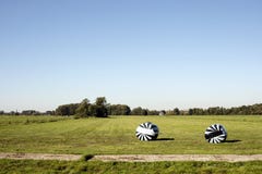 Twee die balen van hooi in zwart-wit gestreept plastiek worden verpakt royalty-vrije stock afbeelding Twee die balen van hooi in zwart-wit gestreept plastiek worden verpakt royalty-vrije stock afbeelding