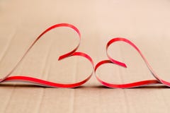 Twee eigengemaakte document rode harten op een beige kartonachtergrond, het symbool van de Dag van Valentine royalty-vrije stock afbeeldingen Twee eigengemaakte document rode harten op een beige kartonachtergrond, het symbool van de Dag van Valentine royalty-vrije stock afbeeldingen