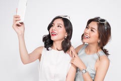 Twee gelukkige Aziatische jonge vrouwen die met smartphone selfie nemen stock foto Twee gelukkige Aziatische jonge vrouwen die met smartphone selfie nemen stock foto