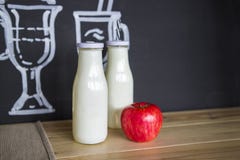 Twee glas witte flessen en een verse appel op de lijst stock afbeeldingen Twee glas witte flessen en een verse appel op de lijst stock afbeeldingen