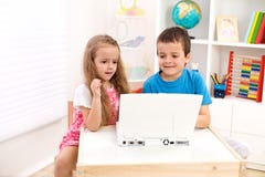 Twee jonge geitjes die laptop computer bekijken stock afbeelding Twee jonge geitjes die laptop computer bekijken stock afbeelding