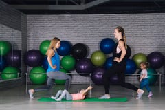 Twee jonge sportenmamma en baby girls do exercises samen in stock foto Twee jonge sportenmamma en baby girls do exercises samen in stock foto