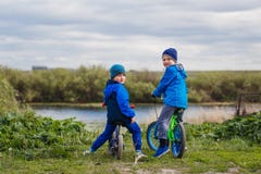 Twee jongenskleuter die op fietsen de camera bekijken stock afbeelding Twee jongenskleuter die op fietsen de camera bekijken stock afbeelding