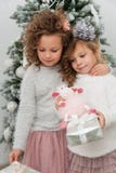 Twee kindmeisjes met giften en schapenstuk speelgoed dichtbij Kerstmisboom Royalty-vrije Stock Fotografie Twee kindmeisjes met giften en schapenstuk speelgoed dichtbij Kerstmisboom Royalty-vrije Stock Fotografie