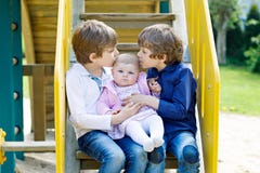 Twee kleine gelukkige jong geitjejongens met pasgeboren babymeisje, leuke zuster stock fotografie Twee kleine gelukkige jong geitjejongens met pasgeboren babymeisje, leuke zuster stock fotografie
