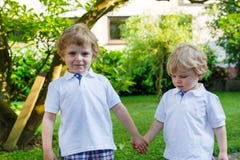 Twee kleine sibling jongens die pret in openlucht in familie hebben kijken stock foto's Twee kleine sibling jongens die pret in openlucht in familie hebben kijken stock foto's