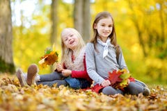 Twee kleine zusters die pret samen in mooi de herfstpark hebben stock fotografie Twee kleine zusters die pret samen in mooi de herfstpark hebben stock fotografie