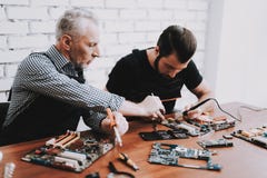 Twee Mensen die Hardwaremateriaal van PC herstellen royalty-vrije stock afbeelding Twee Mensen die Hardwaremateriaal van PC herstellen royalty-vrije stock afbeelding