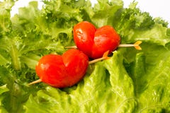 Twee rode tomatenkers op de groene ijsbergsalade en de citroen slidce stock afbeelding Twee rode tomatenkers op de groene ijsbergsalade en de citroen slidce stock afbeelding