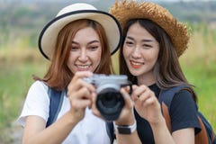 Twee toeristenvrouw die een foto met camera in aard nemen stock afbeelding Twee toeristenvrouw die een foto met camera in aard nemen stock afbeelding